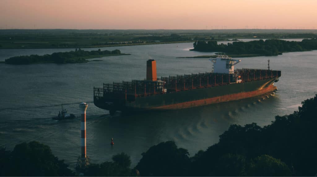 Bateau industriel sur une belle rivière au couché de soleil